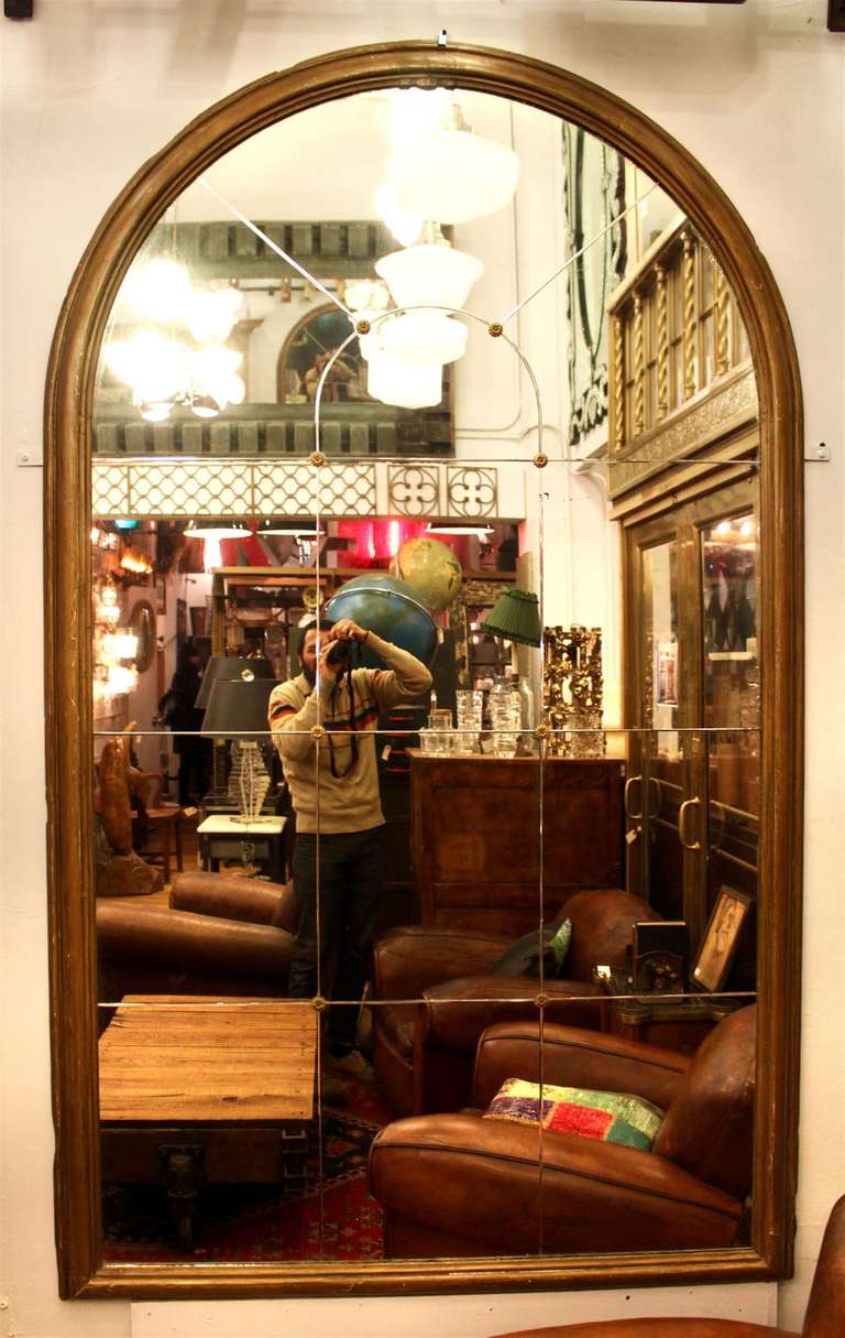 Antique arched divided mirror with a gold painted frame and brass rosettes from a NYC residence. Palladium style. This item can be seen at our 149 Madison Avenue store at 32nd St in Manhattan.