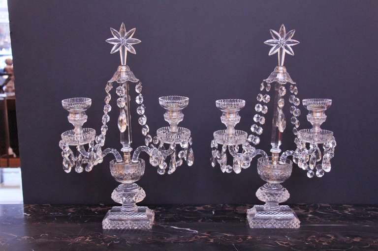 Elegant pair of two arm crystal candelabras. One bobeche has some scratches. This can be viewed at one of our New York City locations. Please inquire for the exact address.