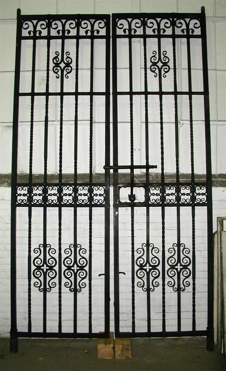 Early 1900s pair of iron gates by Samuel Yellin, considered to be one of the greatest artist blacksmiths. Salvaged from a Philadelphia bank. The frame of each door is exactly 118.25 in. tall and 35 in. wide, and the frame itself is 1.25 in. thick.