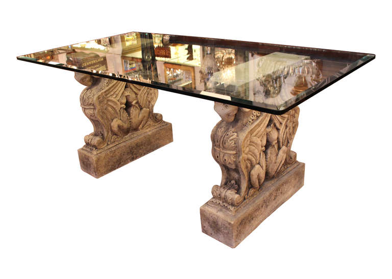 Salvaged antique double griffin pedestals form the bases for this beveled glass topped table.