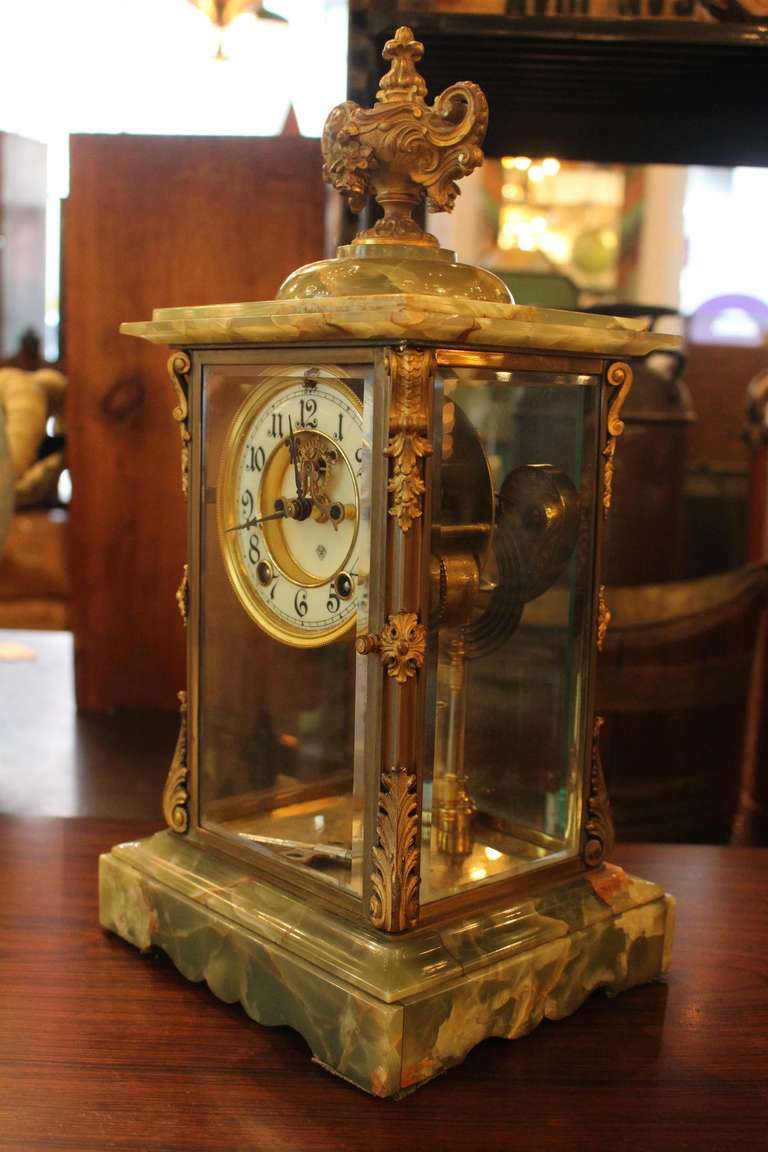 This clock is made of green onyx with bronze detailing.  This item can be seen at our 149 Madison Avenue store at 32nd St in Manhattan.