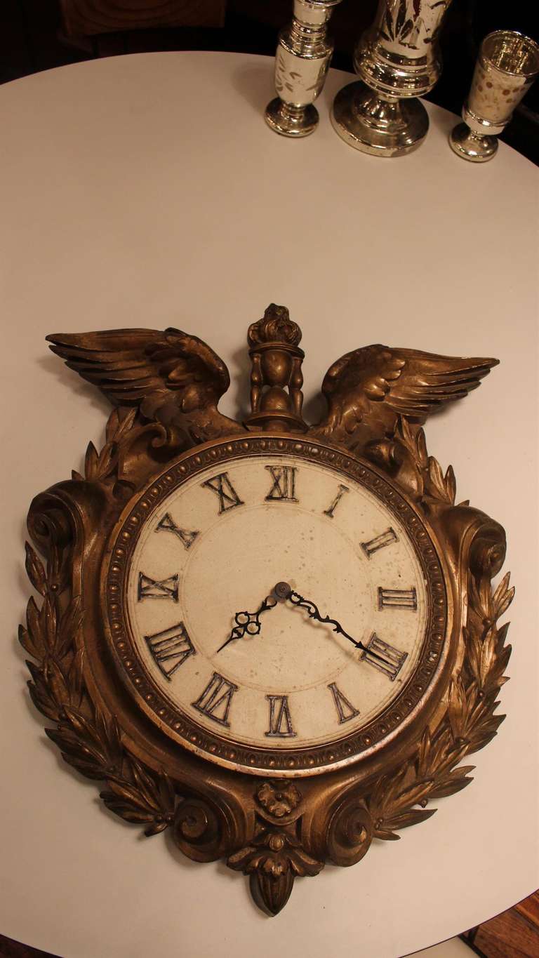 Roman numerals, eagle wings and a wreath motif adorn the face of this bronze plated clock. Original movement replaced with modern battery operated movement. This can be seen at our 400 Gilligan St location in Scranton, PA.
