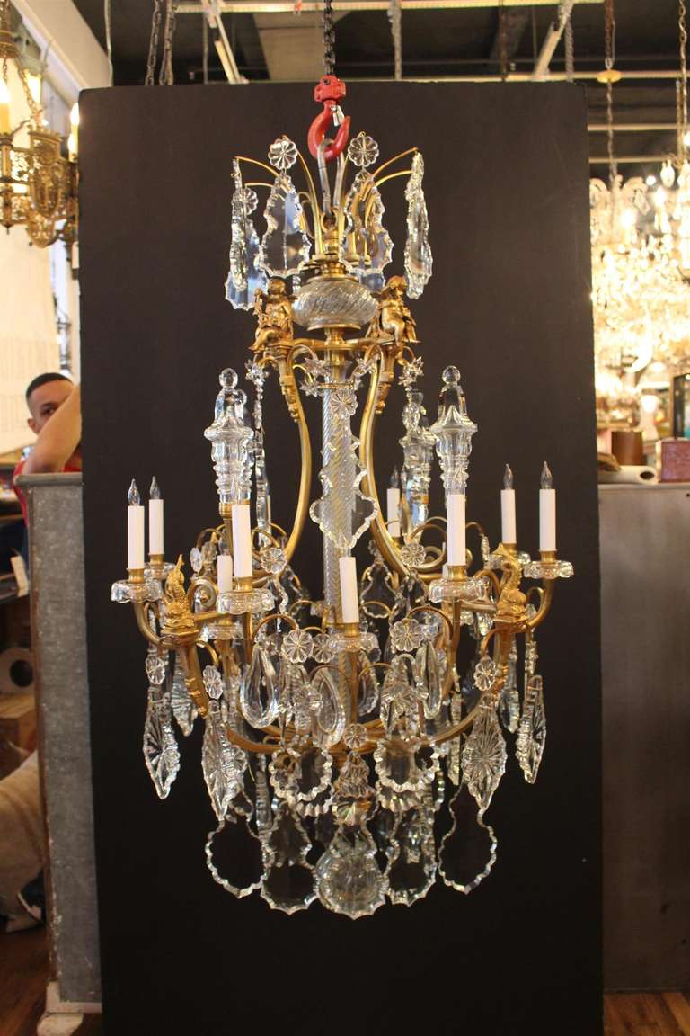 Pair of bronze and crystal Louis XV style chandeliers, hung with tear drops, prismatic rosettes, bronze dolphins and angels, terminating with a cut crystal ball. Priced for both. This can be seen at our 2420 Broadway location on the upper west side