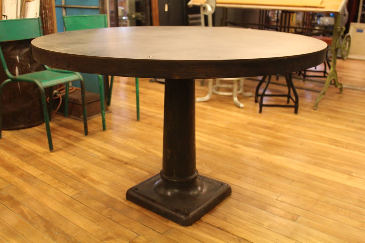 The base is an antique Mummer Dixon machinery pedestal from the turn of the century. The tabletop is hot rolled steel which has been beautifully finished. Custom tabletop sizes available. This base is unique, so ask us about our selection of other