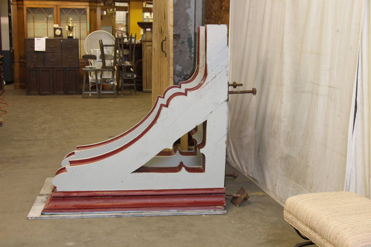 Pair of oversized Gothic wooden corbels with very light blue and red paint. These can be seen at our 400 Gilligan St, Scranton, PA warehouse.