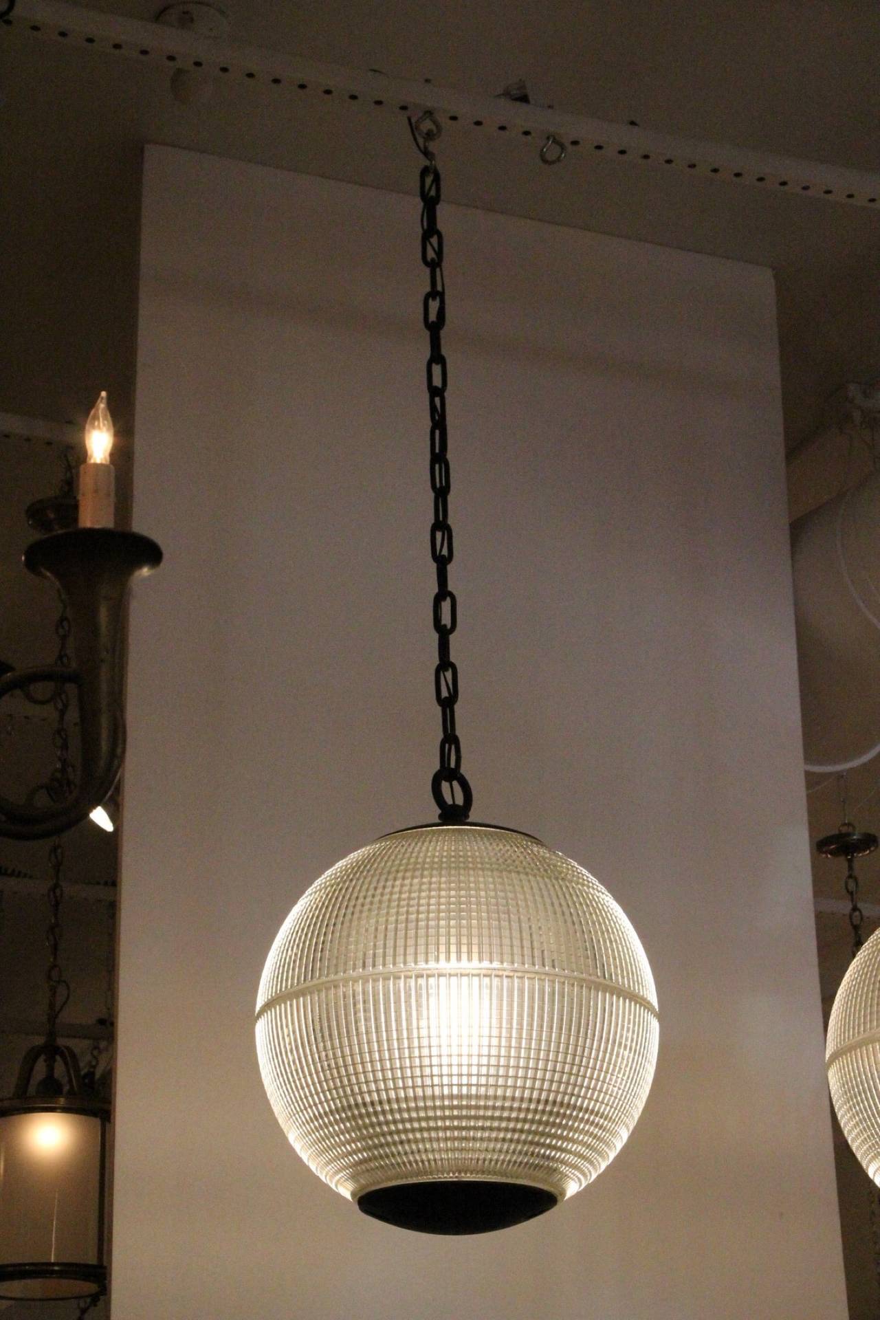 This is an original late 1960s Paris globe Holophane street light from Paris, France now turned into a pendant light. The hallmark of Holophane luminaries, or lighting fixtures, is the borosilicate glass reflector / refactor. The glass prisms (ribs)