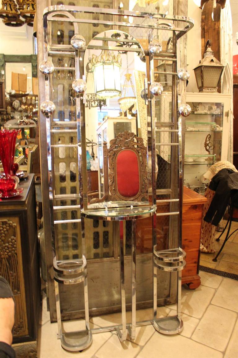 This is a large mirrored hall tree with eight chrome buttons and two sections at the base for umbrellas. There is also a small mirrored shelf. This item can be seen at our 5 E. 16th St.,Union Square location.