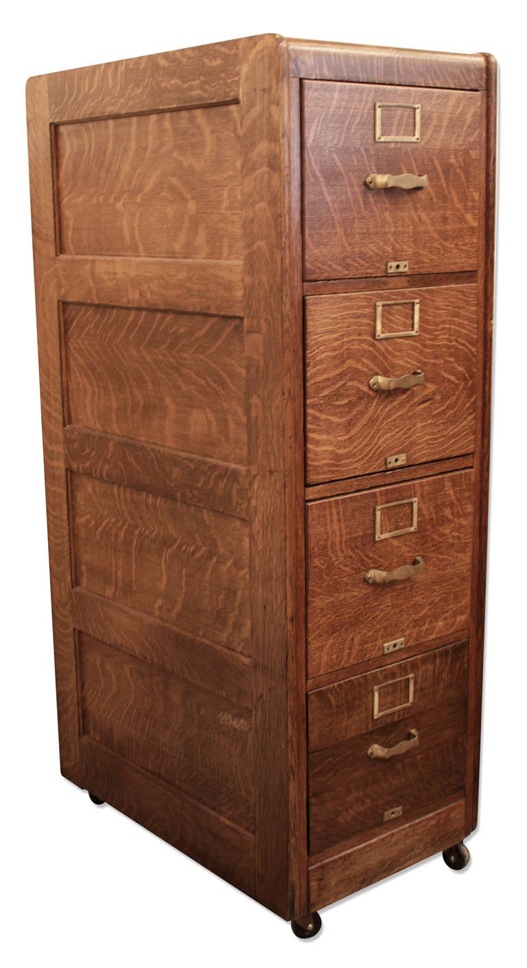 Gorgeous four drawer mint condition tiger oak filing cabinet with brass drawer pulls and file label slots.  The cabinet is set on casters for easy movement.  This can be seen at our store on Union Square at 5 East 16th St. in Manhattan.