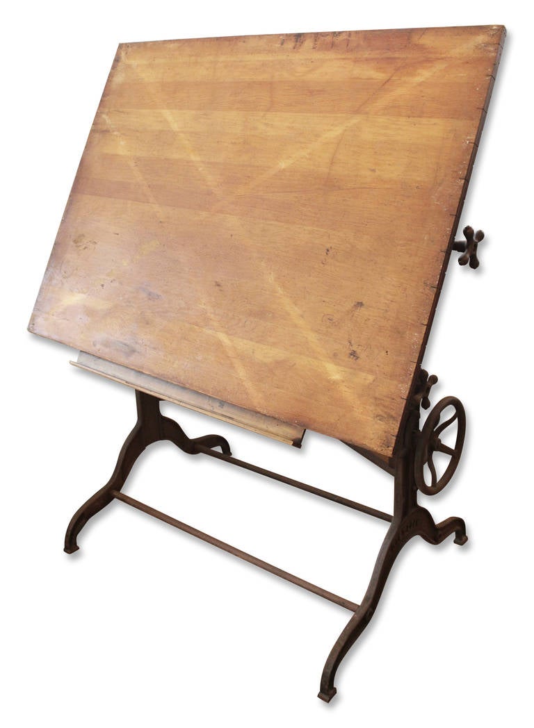 Large 19th century drafting table with hand painted black cast iron base. There are wheels, gears and knobs to raise, lower and adjust the tilt of the top.  The base is marked Dietzgen. Made in U.S.A.  This item can be seen at our 149 Madison Avenue