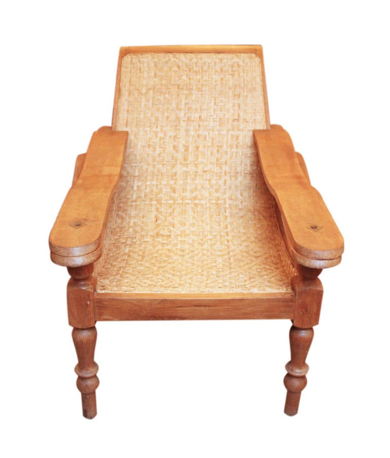 This gracious plantation chair has a low seat, sloping back and rattan caning. A swing out leg rest is concealed beneath the armrest. The footrest elevated the legs and feet to increase cooling with cross ventilation and made removal of riding boots