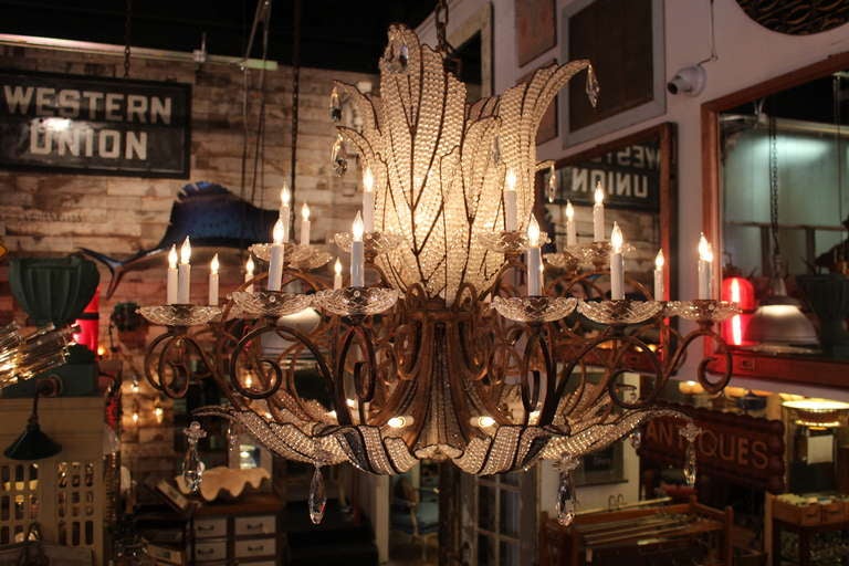 Remarkable Italian 1930s wrought iron chandelier with hand strung beads throughout. Eight arms in total. This item can be seen at our location at 149 Madison Ave in Manhattan.