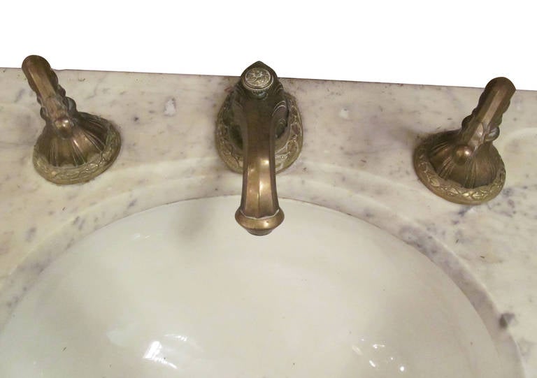 Complete sink with bowl and ornate brass hardware. White Carrara marble. This item is located at our 124 West 24th Street, New York location.