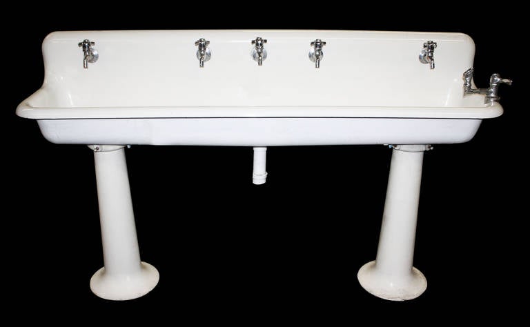 This is an original porcelain over cast iron gang sink. Mounted on two 'elephant' pedestal legs. The legs are removable for easy shipping. Please note this sink no longer has hardware. This item is located at our 400 Gilligan Street, Scranton PA