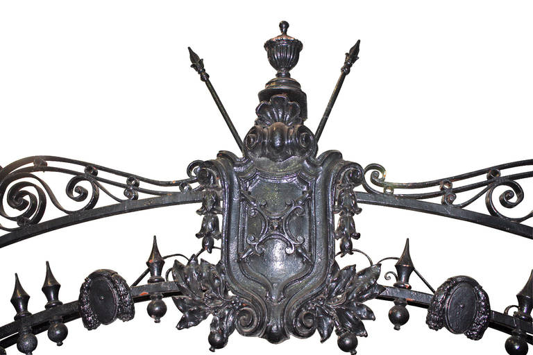 This is an ornate wrought iron entry arch from the 1900s. It makes a grand entrance for a driveway or other entrance. It is in excellent condition as it has been well-preserved with paint over the years. This can be seen at our National Warehouse at