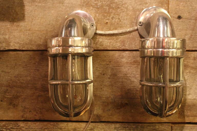 A pair of iconic nautical aluminum cage lights in perfect working condition.  Can be rewired to take a small candelabra bulb. These can can be seen at our 5 East 16 Street location in Manhattan.