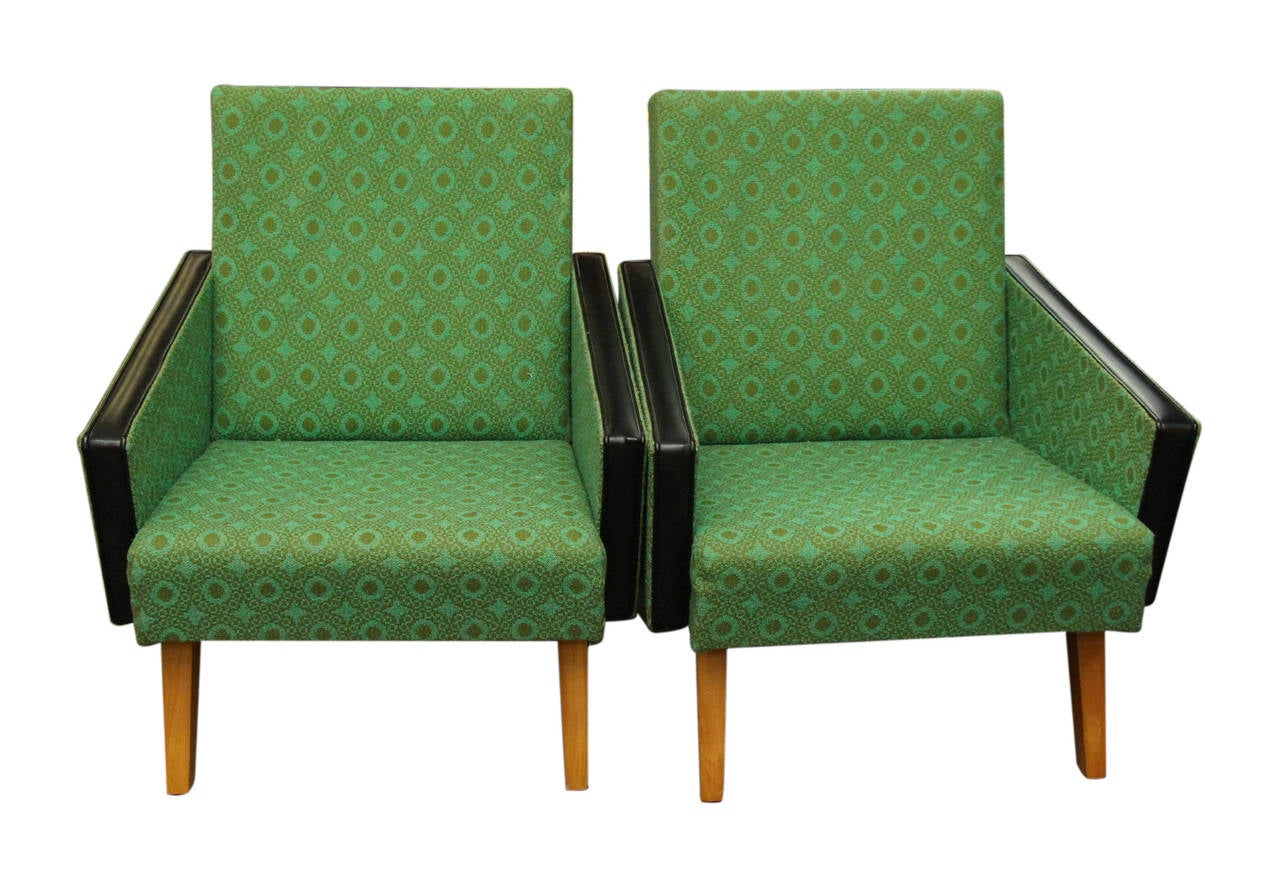 1950s pair of Mid-Century Modern green and black angular armchairs from France. Mid-Century Modern green printed vinyl angled armchairs with square wooden legs. The edging on the angled arms is a black vinyl helping to contrast the piece. These can