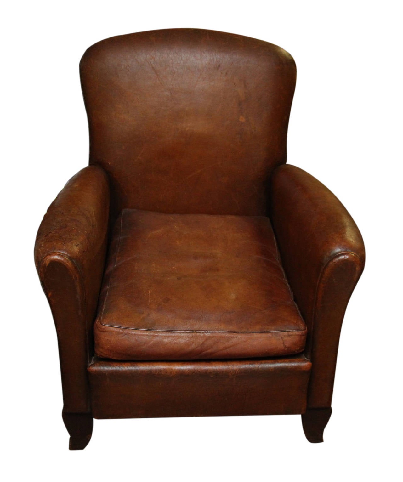 Petite Art Deco leather club chair. This chair sits on four wooden legs and is light brown in color. The arms are small and rounded with a rounded corner back. This item can be viewed at our 400 Gilligan Street, Scranton, PA warehouse.