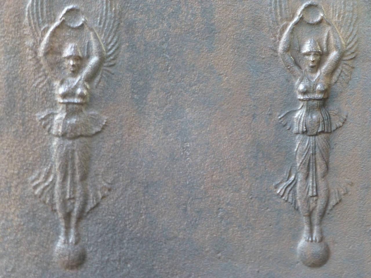 Neoclassical fireback with angels with a wreath (symbolizing victory) and standing on a sphere (symbolizing risk taking).