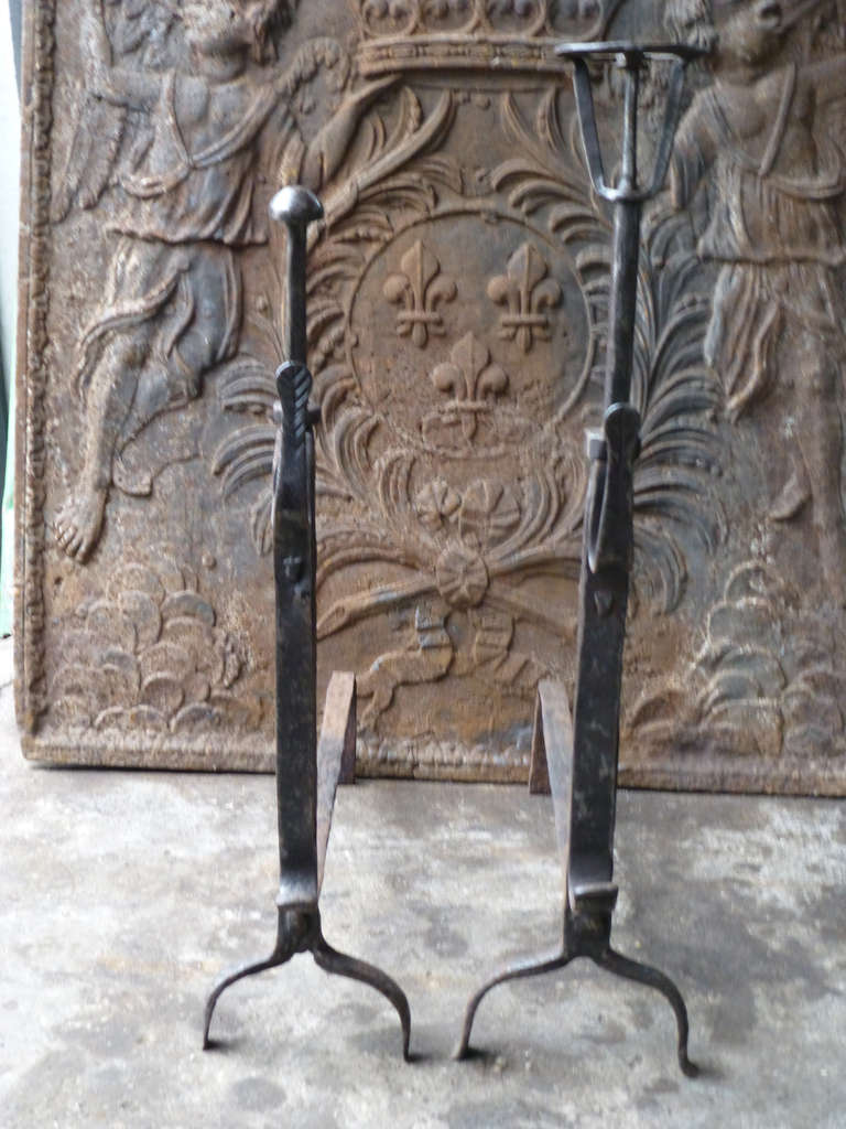 Wedding pair of andirons whereby both parties donate one andiron from the same blacksmith. With spit hooks. These French andirons are called 'landiers' in France. This dates from the times the andirons were the main cooking equipment in the house.