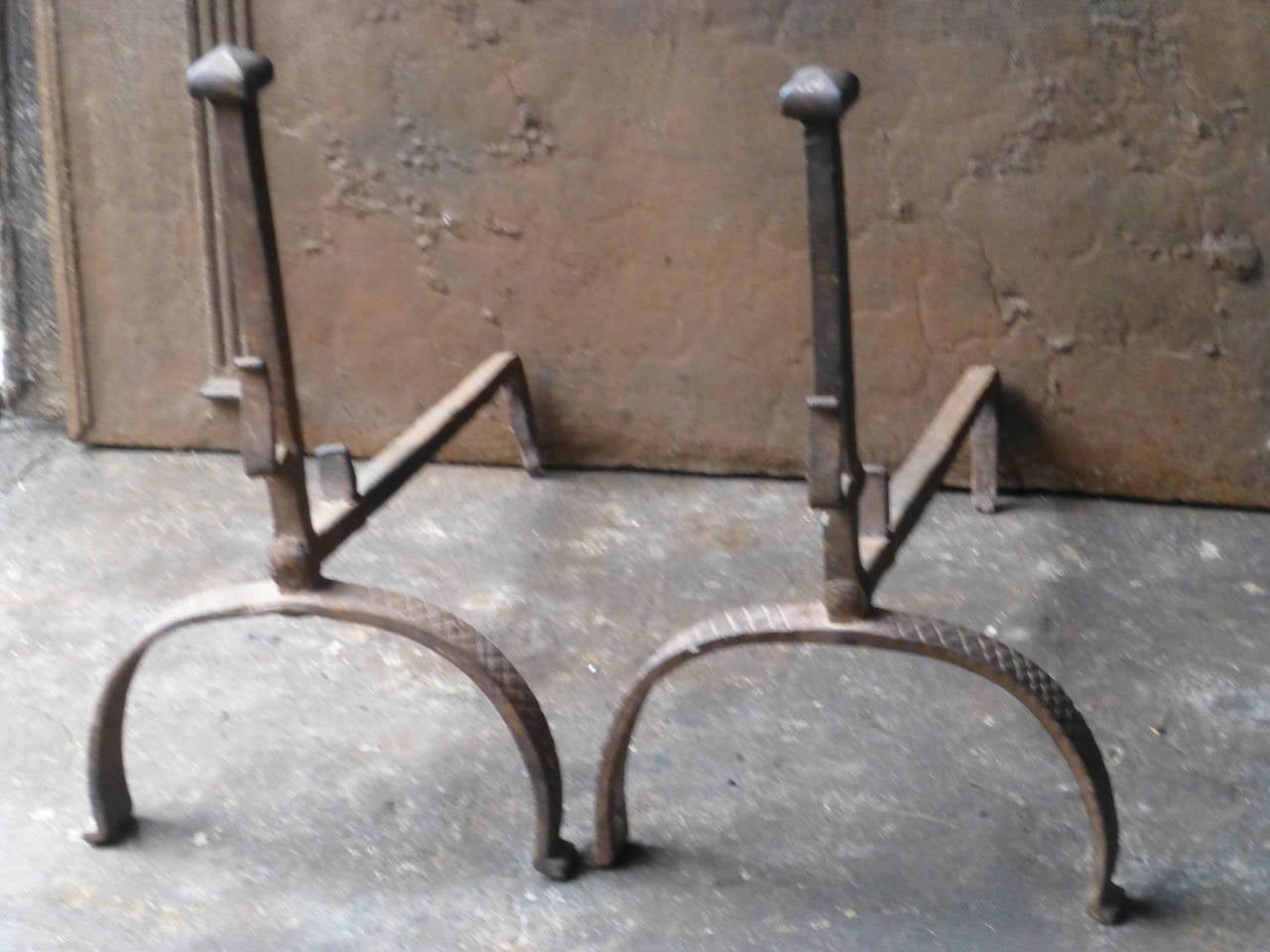 Wrought iron fire dogs with spit hooks.

We have a unique and specialized collection of antique and used fireplace accessories consisting of more than 1000 listings at 1stdibs. Amongst others, we always have 300+ firebacks, 250+ pairs of andirons