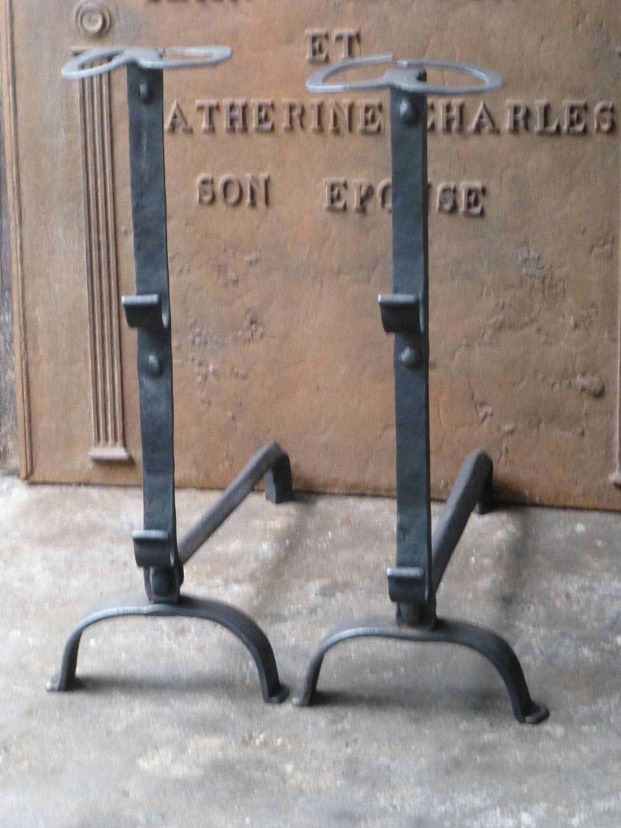 Large wrought iron fire dogs with spit hooks. These French andirons are called 'landiers' in France. This dates from the times the andirons were the main cooking equipment in the house. They had spit hooks to grill meat or poultry and sometimes a