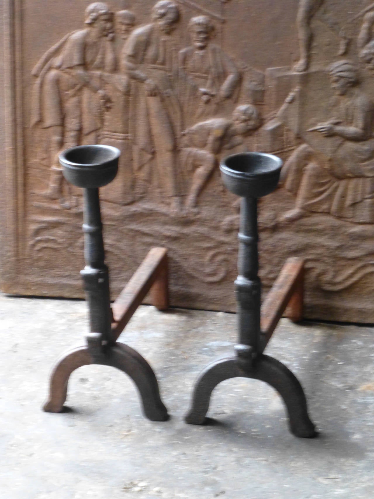 Cast firedogs with spit hooks to grill food and a cup to keep drinks or soup warm.

We always have 350+ pair of antique andirons - fire dogs in stock that can be ordered on line. See our website for our current stock and prices.