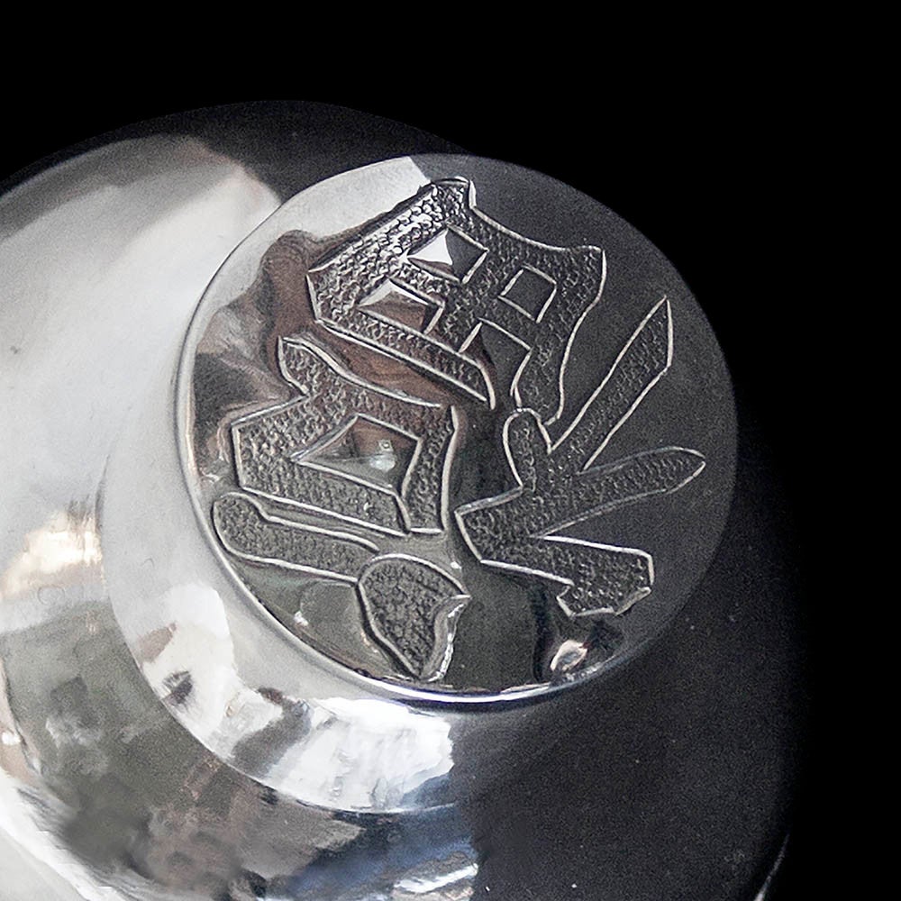 A tea caddy of ovoid body shape with rounded shoulders and flat base the body decoratively chased with a dragon motif. The pull off lid engraved with Chinese characters