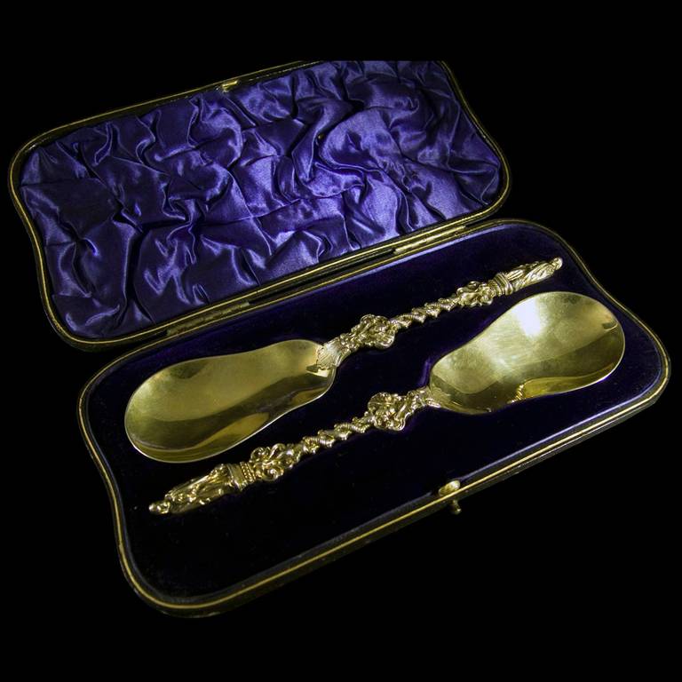 A pair of George V silver gilt, fruit serving spoons in original presentation case by William Hutton & Sons.