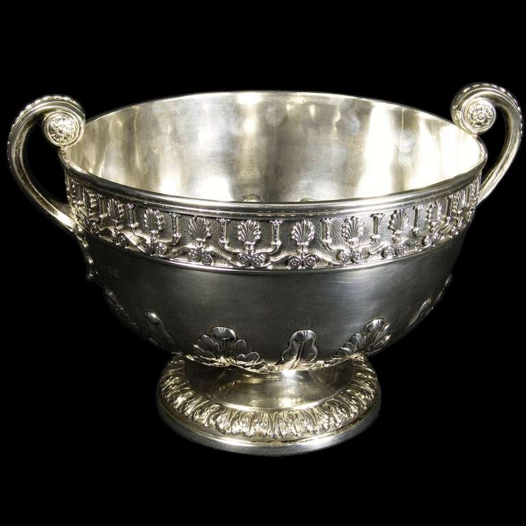 A very good silver two handled bowl on pedestal foot. The body and foot decoratively chased with acanthus leaves and the rim having an applied cast floral border.The bowl stand 193mm to top of handles and the bowl at rim is 232mm in diameter