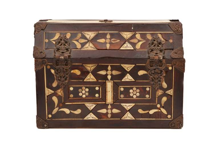 Decorative boxes (or baúls) like this one inlaid with mother-of-pearl were coveted luxury goods. Intricate incised decorations of leaf and floral forms are bordered with simple geometric patterning. An elaborate copper lock adorns the front of the