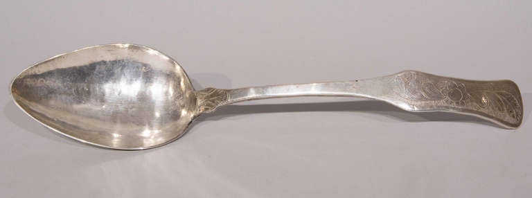 This large silver serving spoon from Bolivia weighs 12 ounces (340.2 grams) and measures 16 inches in length X 3.5 inches wide X 2 inches deep. It is substantial, with a lovely and simple floral engraved handle and stem.
