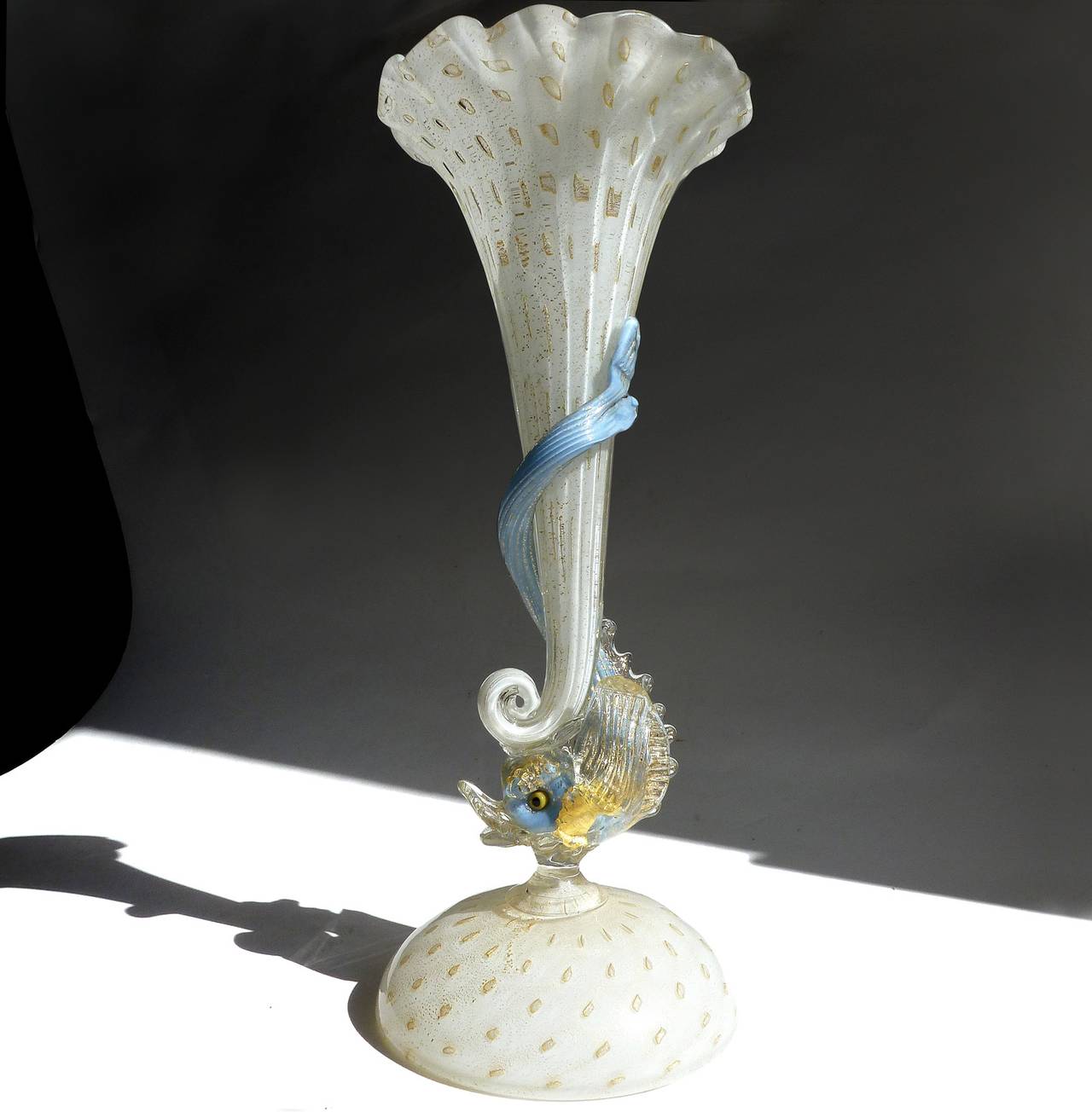 Free shipping worldwide! See details below description.

Elegant Murano handblown white, gold flecks and ruffled rim trumpet vase with blue fish decoration. Attributed to the Salviati Company, circa 1950s. The piece is very well detailed and
