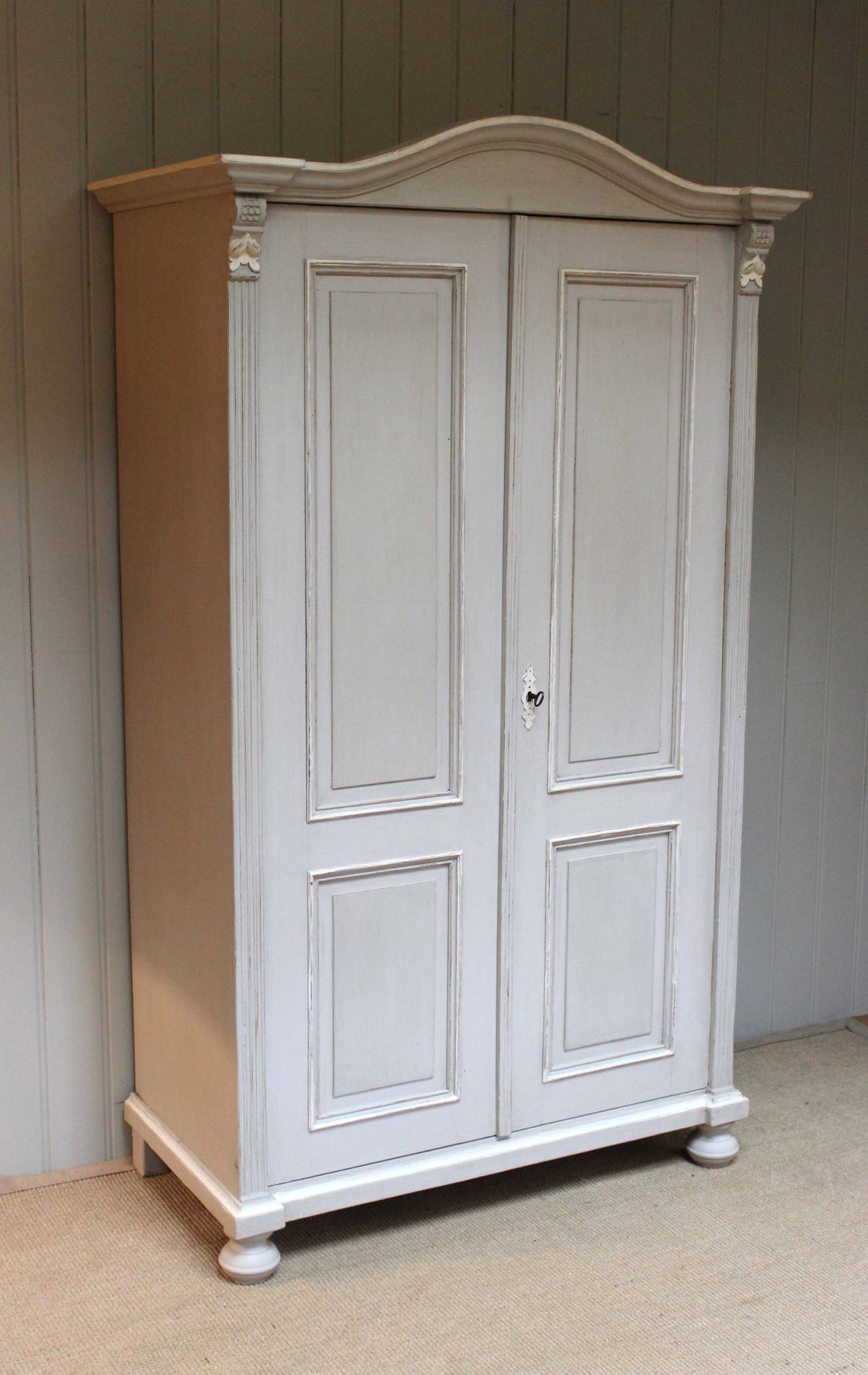 Continental painted two door wardrobe having fielded panelled doors with reeded side piliasters having a carved leaf detail.Fitted internally with a shelf and hanging rail (the internal depth is 40 cm) 
Approximate uk delivery cost for this item