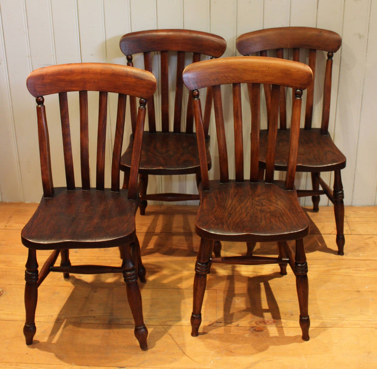 A set of four Lath back Windsor Chairs. Of traditional form, having a beechwood frame and rail and back with a figure elm seat. 
The seat is 43cm high from the floor