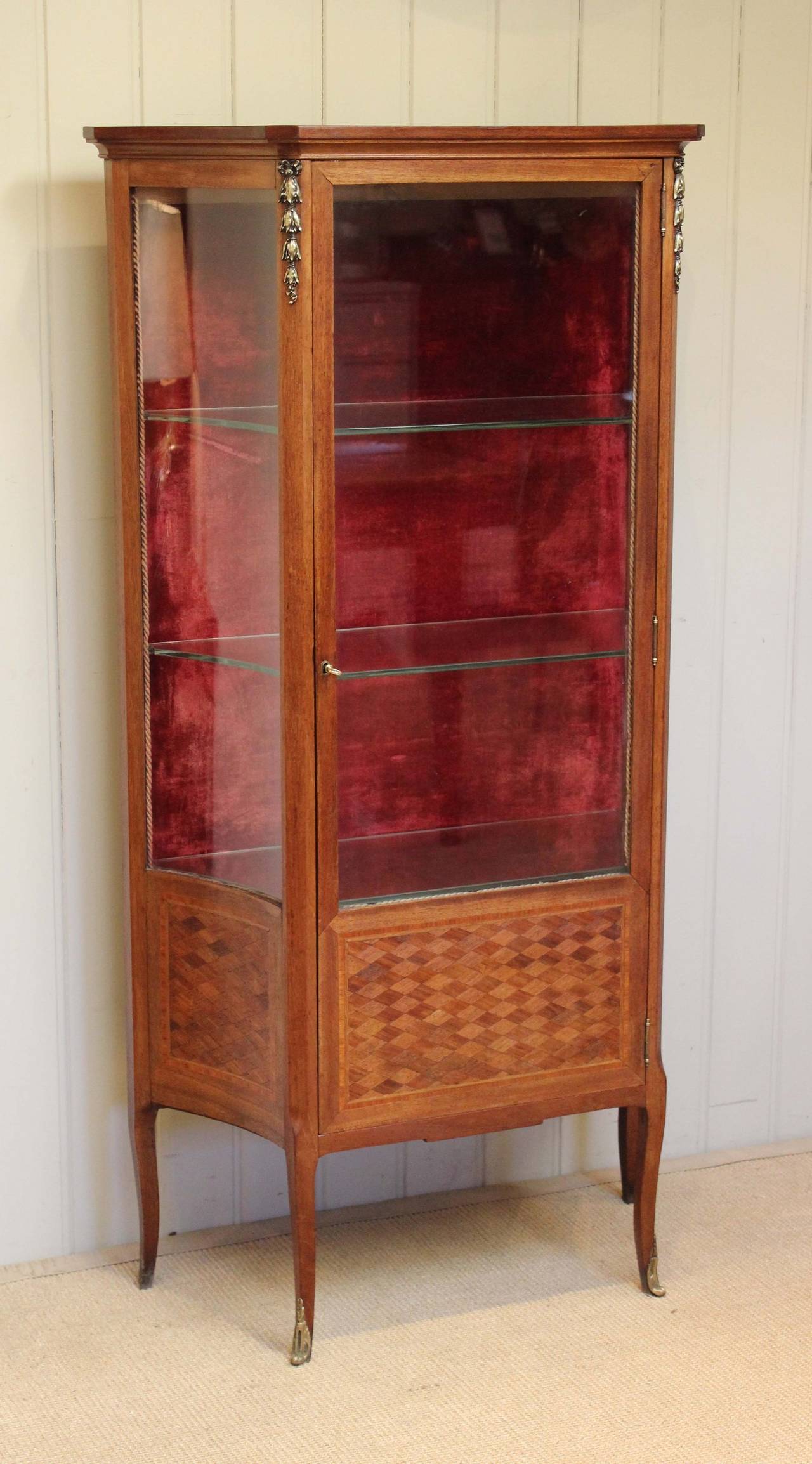 French early 20th century mahogany display cabinet having kingwood and satinwood parquerty to the base with gilt metal mounts and three glass shelves raised on cabriole legs