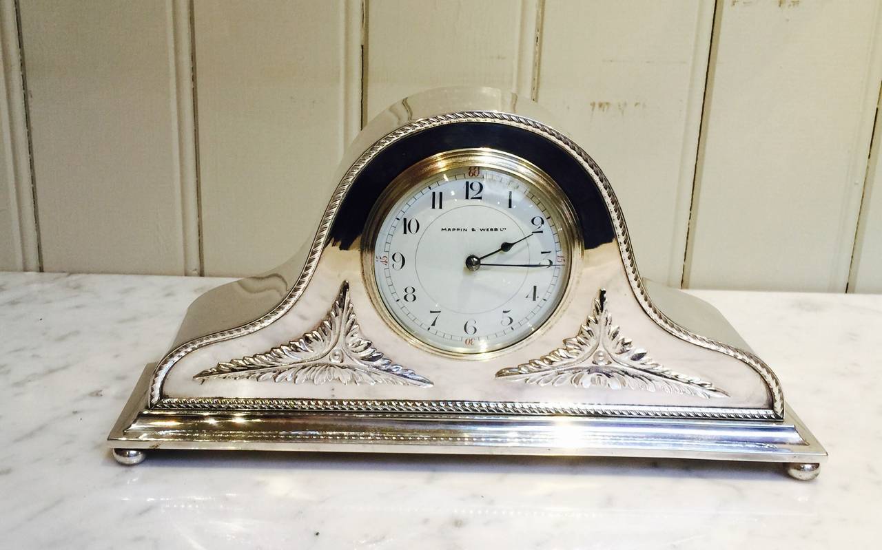 An attractive silver plated mantel clock in the form of a Napoleon hat, dating to the early 20th Century. It has a swept case with applied silver plated decoration. The French 8 day timepiece movement has an enamel dial (which is signed by the