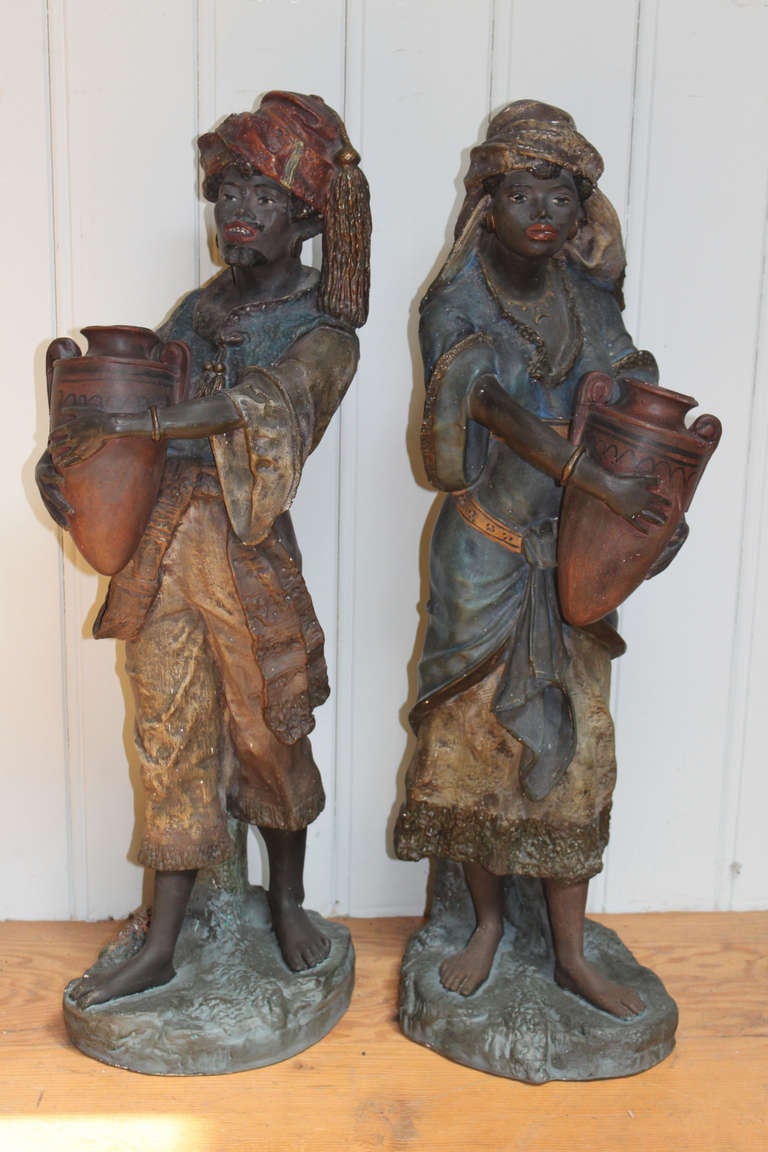Pair of late 19th century naturalistic North African sculptures of plaster composition depicting a male and female carrying water urns.

 Continental.