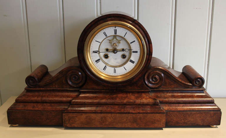 A superb figured burr walnut drum-head mantel clock dating to the Victorian period. It has a circular drum top and a scroll base and a thick bevel edge glass front and back door. The 8 day movement has a visible escapement that swings in time with