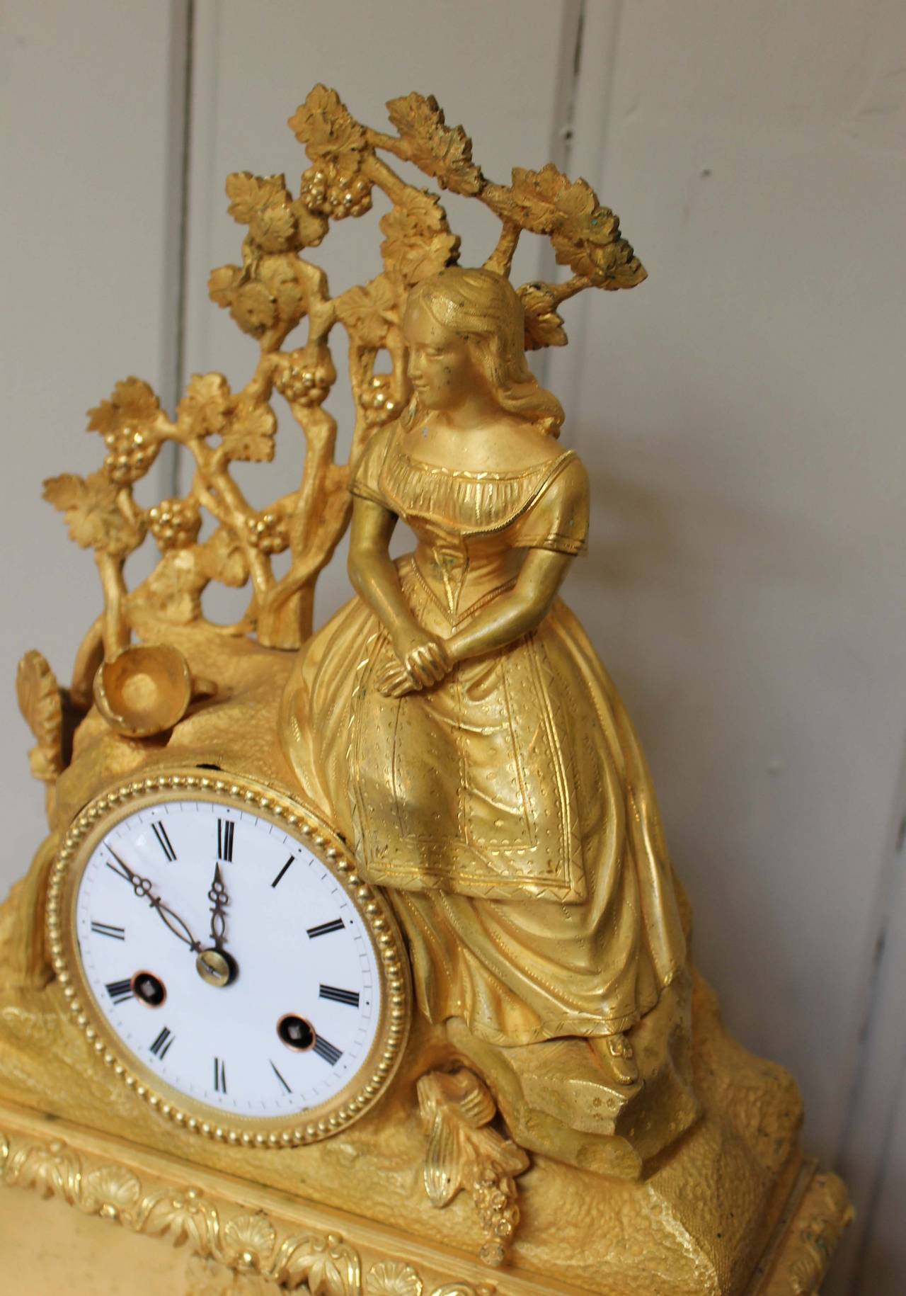 A good quality French mantel clock. It has a heavy gilt ormolu case depicting a classical scene of a maiden with a broken water pail. Below, in the cartouche, is a scene depicting the same maiden filling her water pail. It has an eight day bell