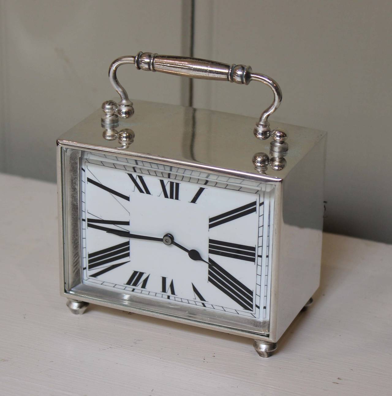 An unusual silver plated carriage clock of oblong form, having a stylised Art Deco numeral dial, with a bevel edge glass. It has an eight-day cylinder platform movement.