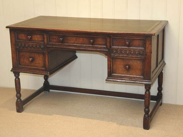 Solid oak 18th century style desk having a green leather scriber above five drawers with a central kneehole section,panelled sides and a joined base. The height of the kneehole is 60cm