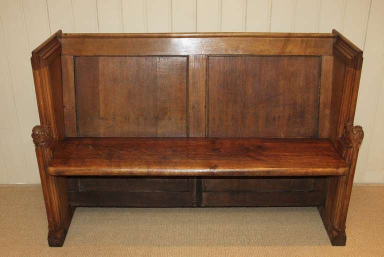 Solid oak church pew from Sheffield cathedral having carved ends with stylized leaves and a rose