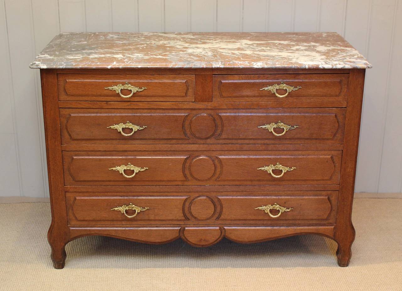 Solid oak chest of two short and three long drawers having a marble top raised on shaped legs