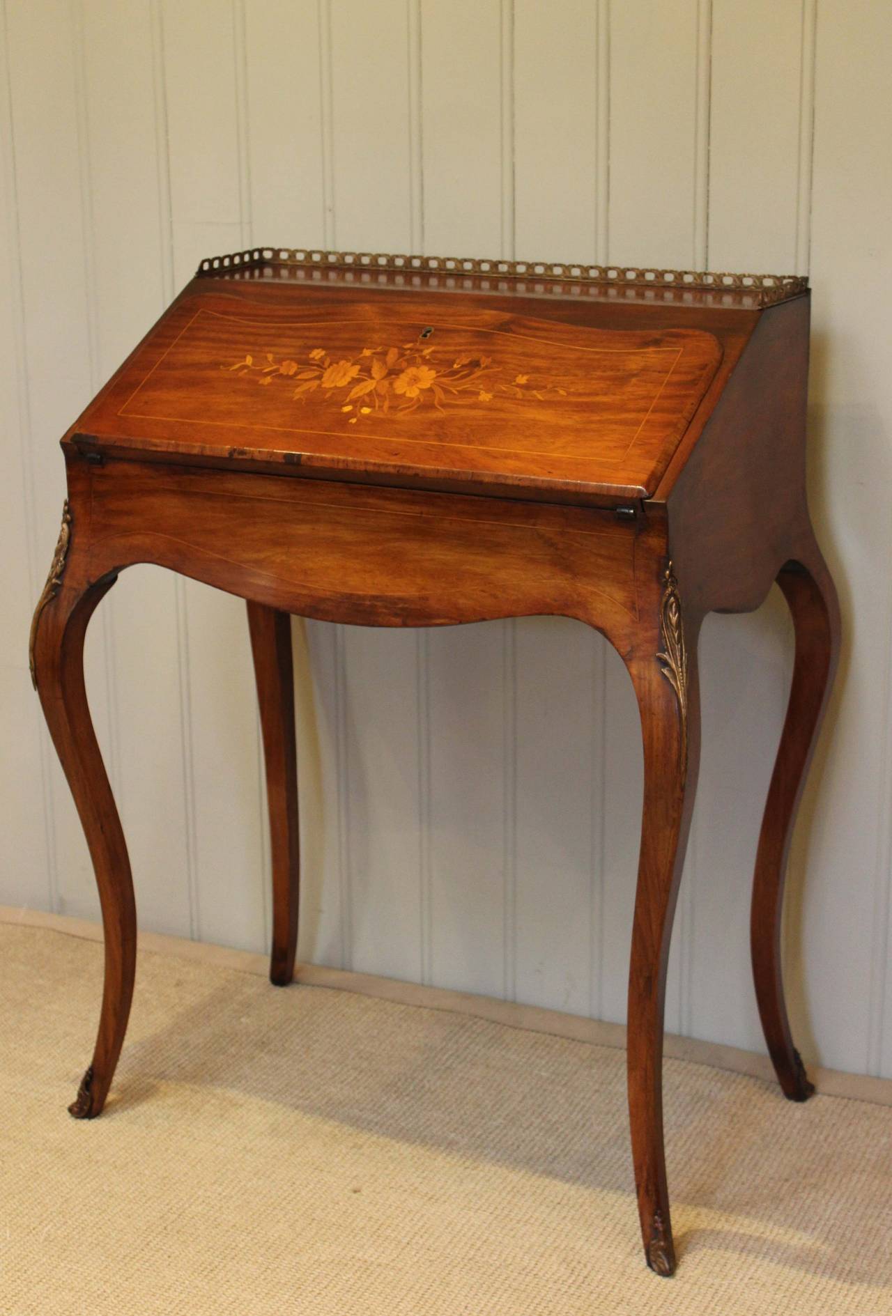 French rosewood bureau de dame having a brass gallery to the top above a marquetry inlaid fall opening to reveal a fitted interior having three drawers and a well raised on cabriole legs