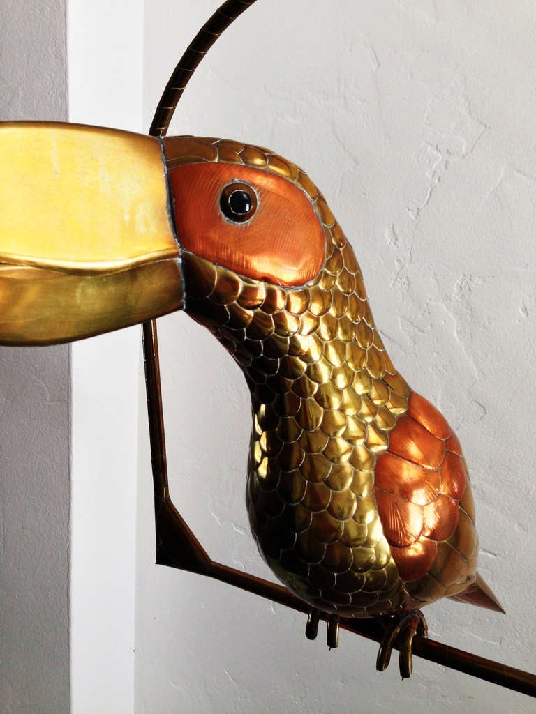 A fine and large mixed metal hanging toucan and perch by Mexican artist, Sergio Bustamante. Item retain original metal finish and patina. Perch measures 21
