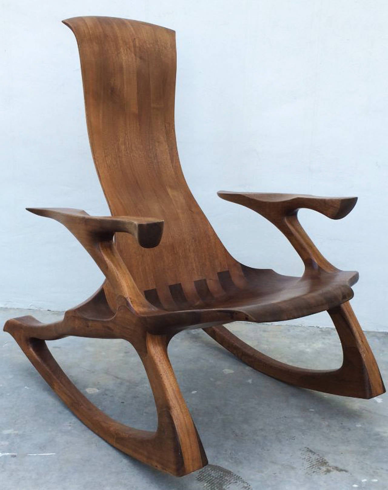 A fine handcrafted and sculpted rocking chair, late 20th century. Laminated and sculpted walnut staved wood item retains original finish. Impressive design and execution. 36.5