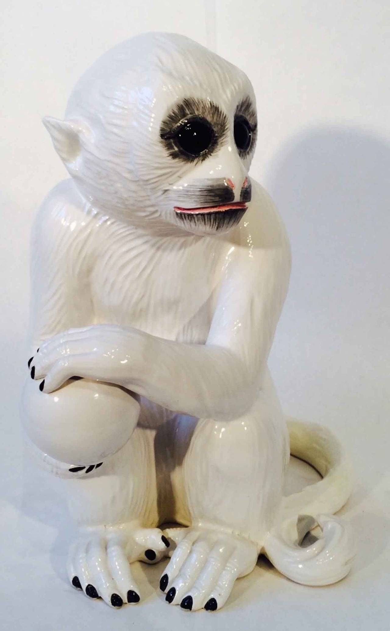 Whimsical lifesize white glazed ceramic sculpture of a monkey holding a ball. Authentic item made in Italy. Pristine.