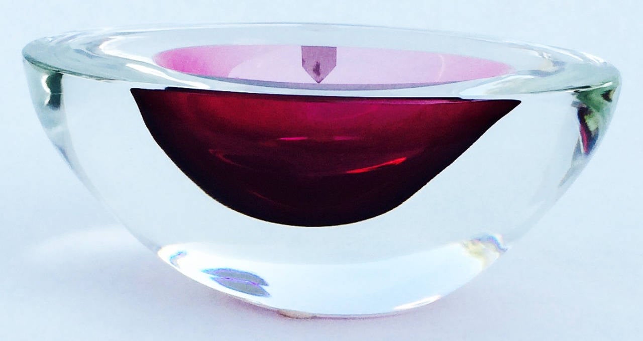 A fine Cenedese Murano glass geode bowl. Signed item features a heavy clear glass item with a rich off center cranberry basin. Item retains original foil label. Pristine with no issues.