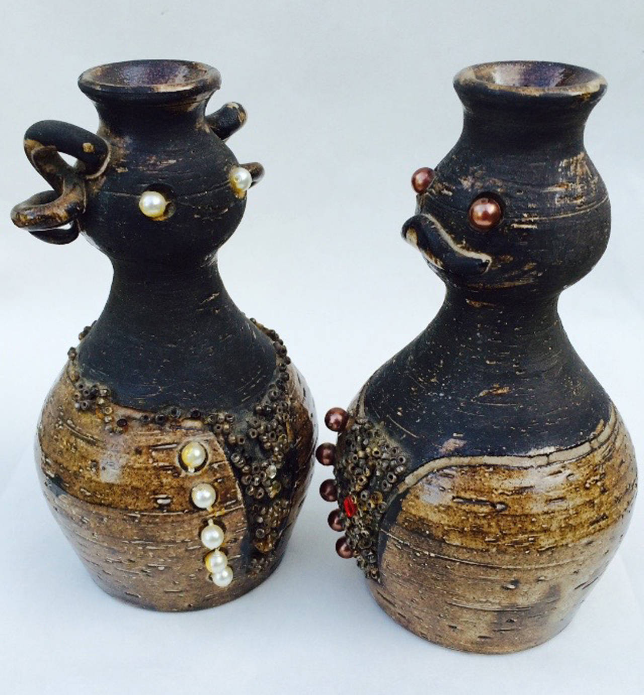A fine and rare pair Bo Borgstrom ceramic bottles. Authentic signed ceramic male and female forms feature additional glass bead, faux pearl and crystal applied decorations. Additional signature for Margit Borgstrom (MF). Single cork stopper intact
