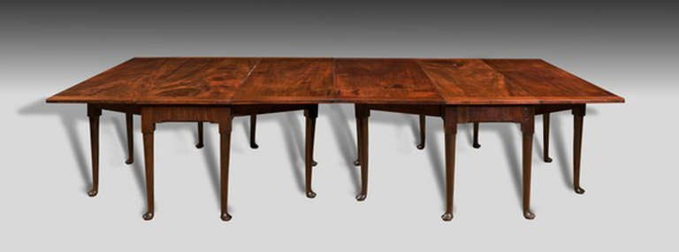 This is a particularly rare form of an early Georgian mahogany dining table; comprising two double drop leaf tables, extending on double outward opening 'gates', all on turned and tapered legs on pad feet.  The additional notes of quality here are